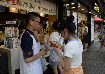 A queue outside a juice shop, two people mid-conversation