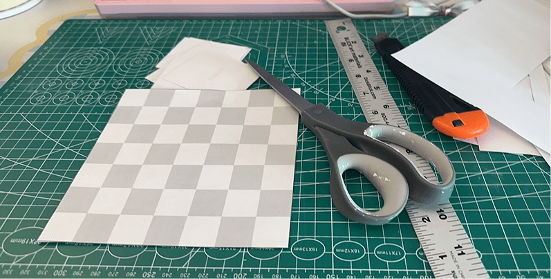 The first paper board being cut on a green cutting mat