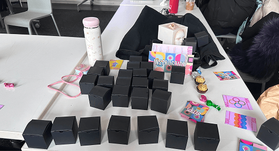 The playtest table set up with the black boxes, the instruction sheet standing open, and cards dealt out